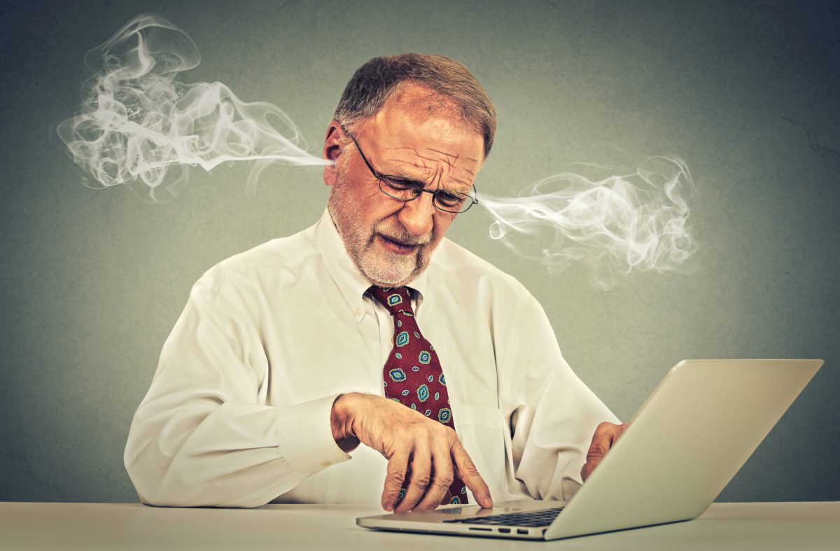 Stressed person using computer blowing steam from ears